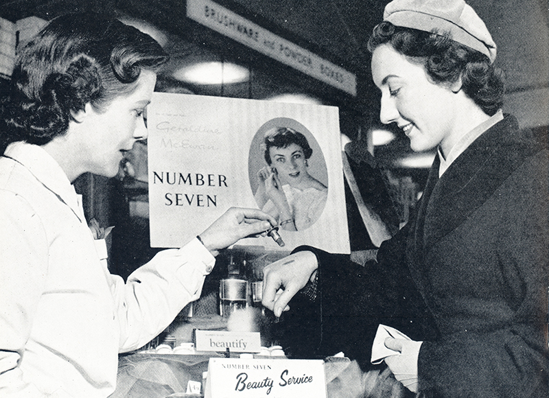 A black and white image of two women testing a No7 lipstick