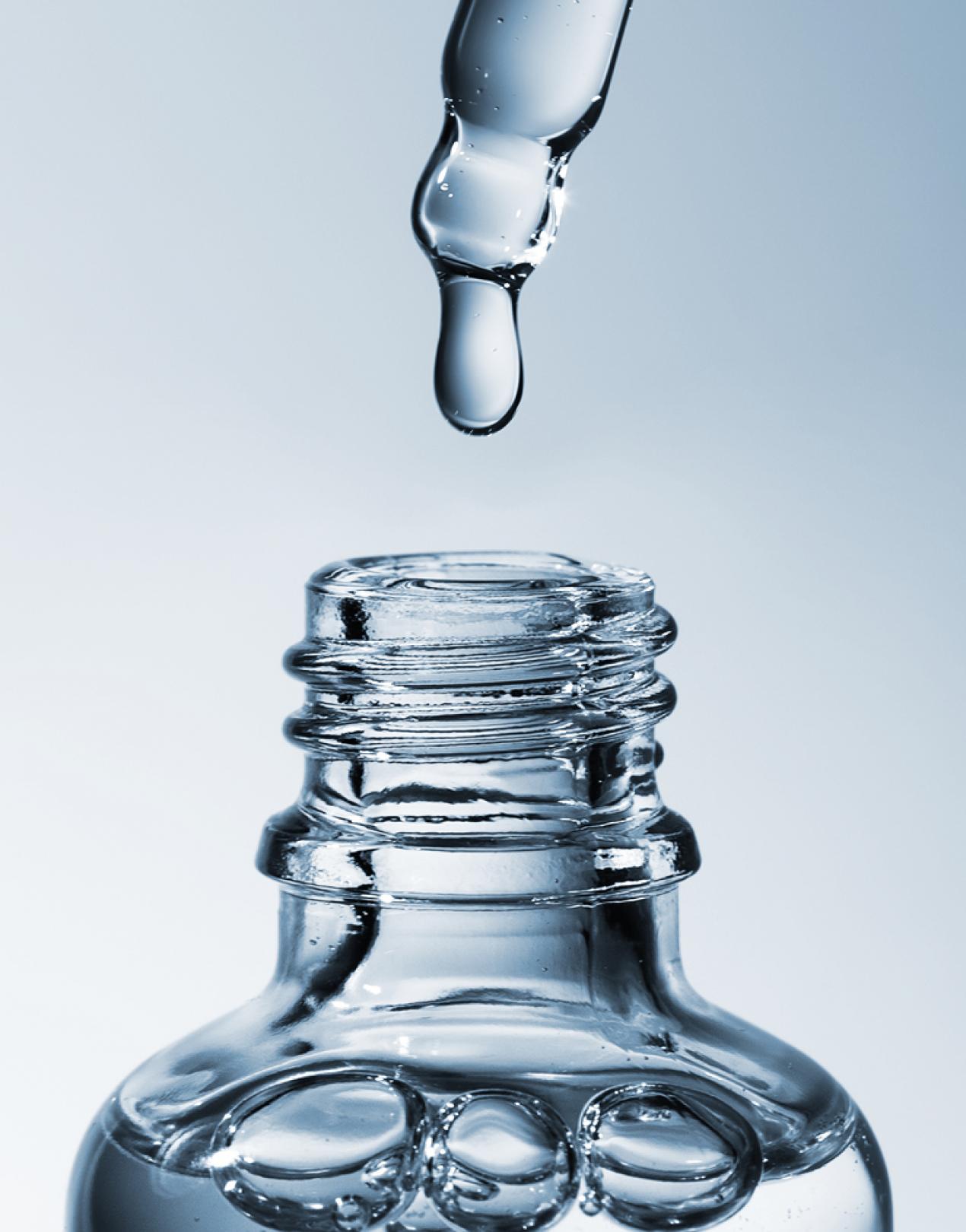 A drop of product falling into a clear bottle