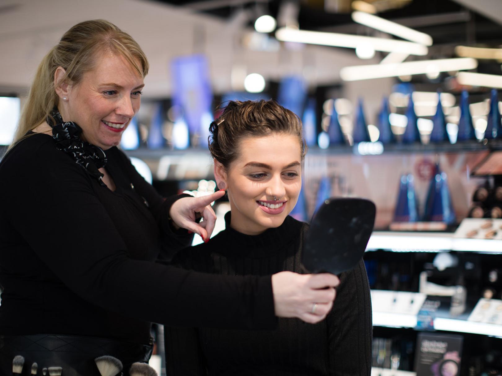Image of Beauty Advisor showing make up on customers face