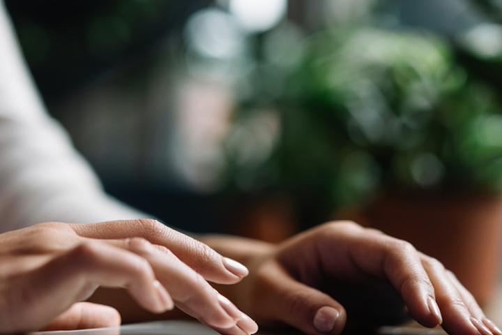 Hands typing on a laptop