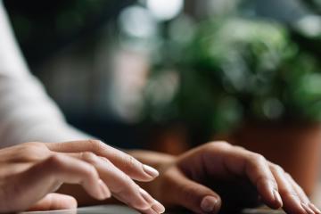 Hands typing on a laptop